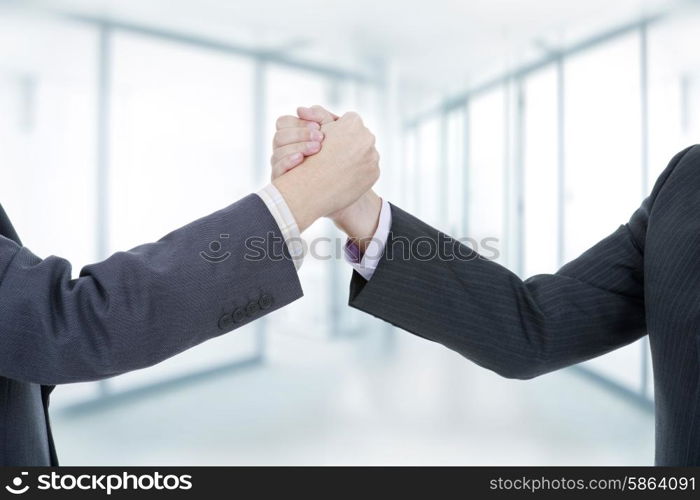 two businessmen in a handshake, at the office