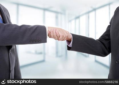 two businessmen in a handshake, at the office