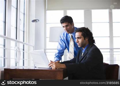 Two businessmen in front of a laptop