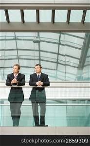 Two Businessmen Leaning at Railing