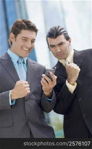 Two businessmen looking at a hand held device