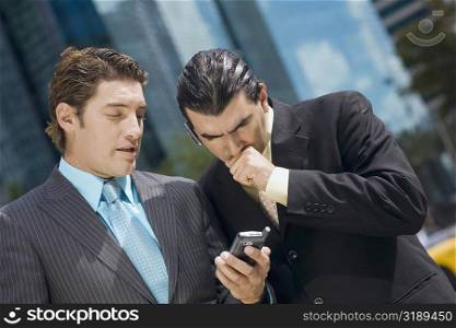 Two businessmen looking at a hand held device