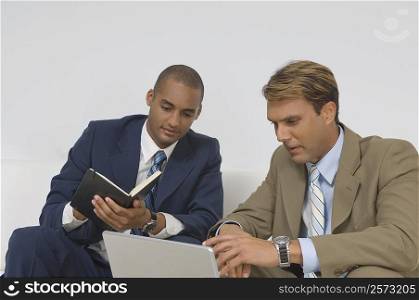 Two businessmen looking at a laptop and having a discussion