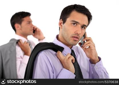 Two businessmen making telephone calls