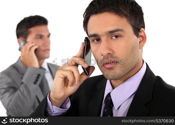 Two businessmen on their mobile telephones