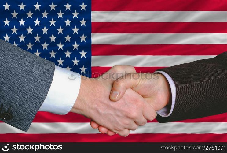 two businessmen shaking hands after good business investment agreement in america, in front of flag