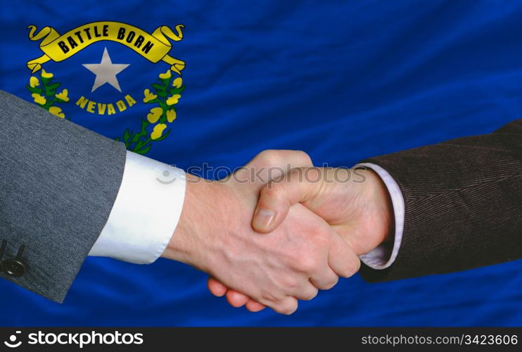 two businessmen shaking hands after good business investment agreement in front US state flag of nevada