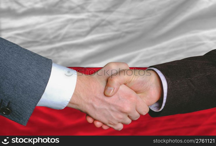 two businessmen shaking hands after good business investment agreement in portugal, in front of flag