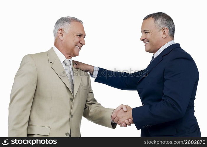 Two businessmen shaking hands and smiling