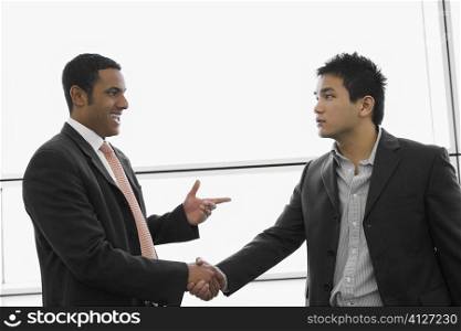 Two businessmen shaking hands at an airport