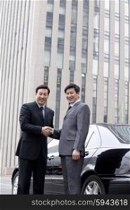 Two businessmen shaking hands outdoors