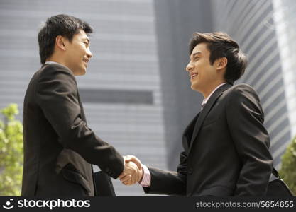 Two Businessmen Shaking Hands Outside Office