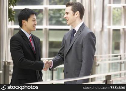 Two Businessmen Shaking Hands Outside Office
