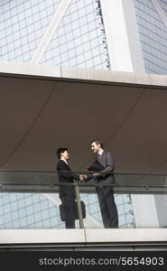 Two Businessmen Shaking Hands Outside Office Building
