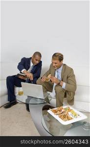 Two businessmen sitting on a couch and having a discussion