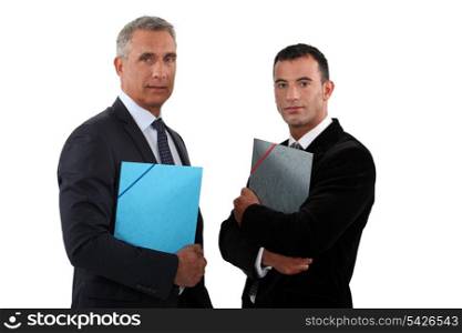 Two businessmen standing and holding files.