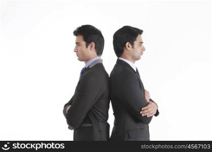 Two businessmen standing back to back