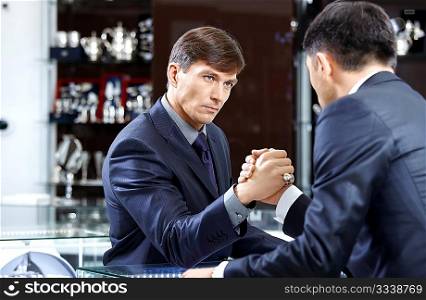 Two businessmen struggle on a forward background