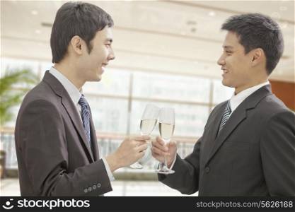 Two Businessmen Toasting Champagne Flutes