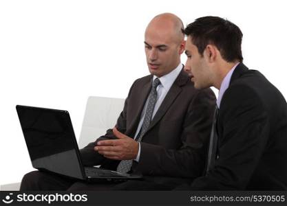 Two businessmen using laptop