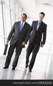 Two businessmen walking in a corridor (high key/selective focus)