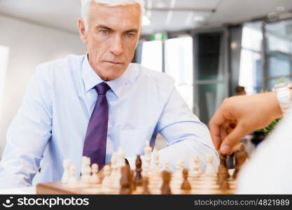 Two businessmen with chess in office. Strategic play