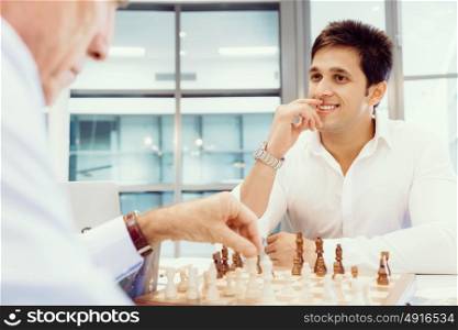 Two businessmen with chess in office. Strategic play