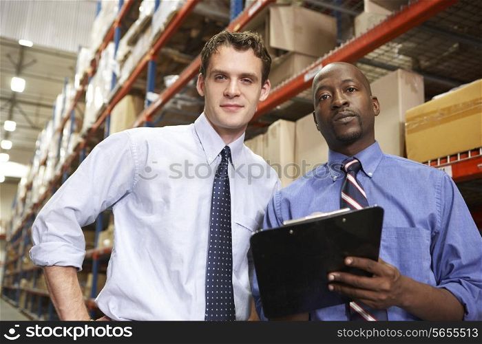 Two Businessmen With Clipboard In Warehouse