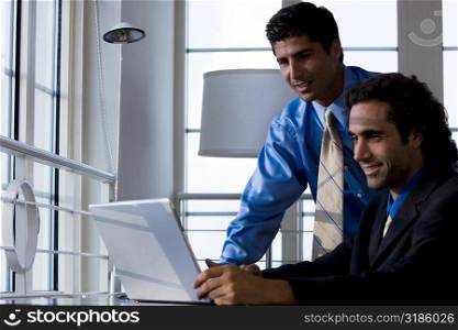Two businessmen working on a laptop