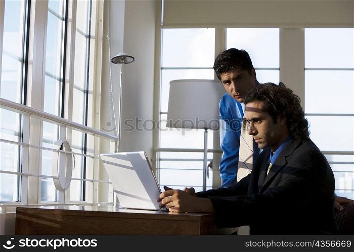 Two businessmen working on a laptop