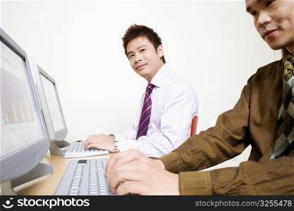 Two businessmen working on computers