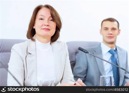 Two businesspeople at meeting. Image of two businesspeople sitting at table at conference