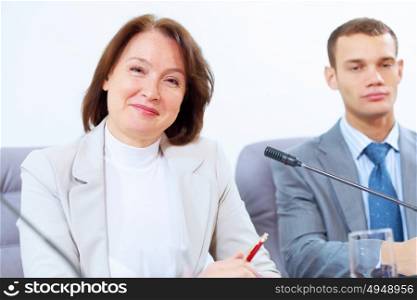 Two businesspeople at meeting. Image of two businesspeople sitting at table at conference