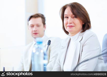 Two businesspeople at meeting. Image of two businesspeople sitting at table at conference