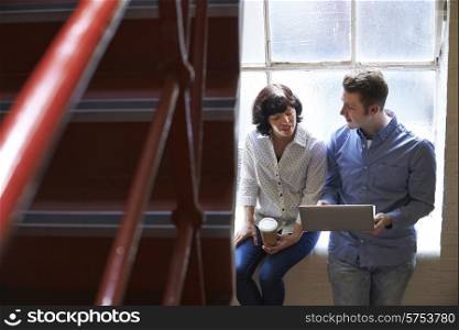 Two Businesspeople Having Informal Meeting On Office Stairs
