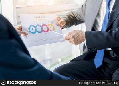 two businesspeople holding infographic elements sheet