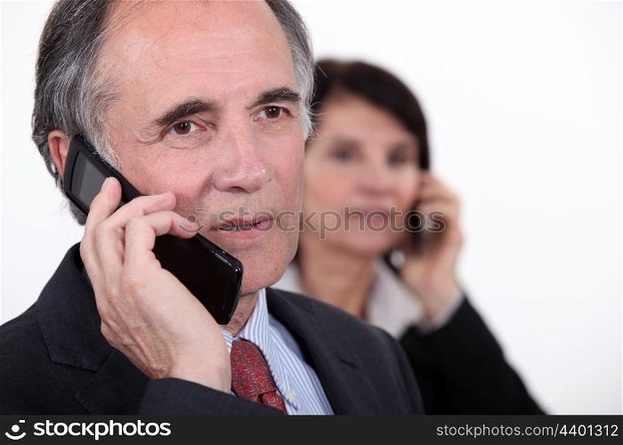 Two businesspeople making phone calls
