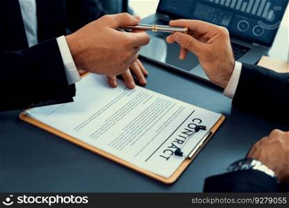 Two businesspeople sit across the desk as business deal is taking place. Corporate attorney giving a pen for client or partner to sign contract paper, sealing the deal with signature. Fervent. Hand giving pen to client or partner for signature. Fervent