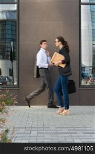 Two businesspeople walking on the street near office building