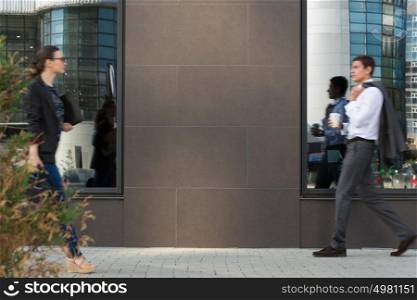 Two businesspeople walking on the street near office building