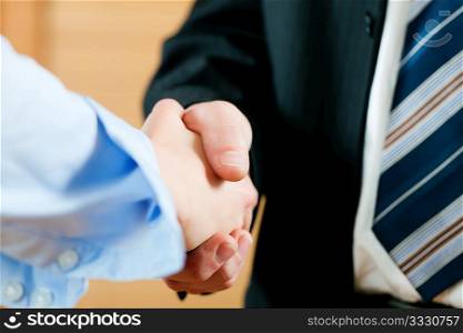 Two businessperson shaking hands; only hands to be seen