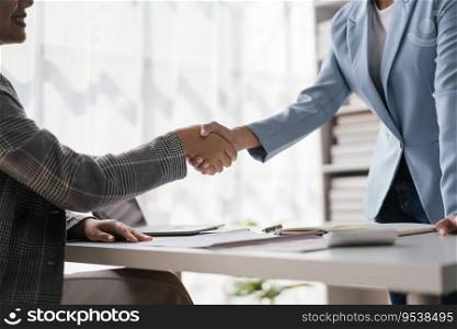 Two businesswoman greeting and shaking hands while discussion about new business project together.