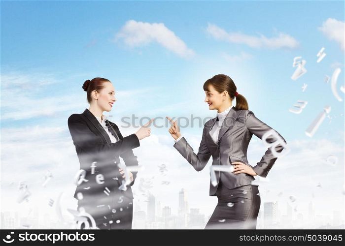 Two businesswomen arguing. Image of two businesswomen in anger shouting at each other