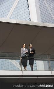 Two Businesswomen Having Discussion Outside Office Building