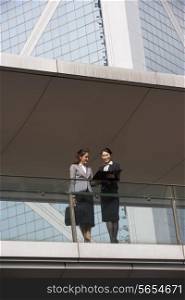 Two Businesswomen Having Discussion Outside Office Building