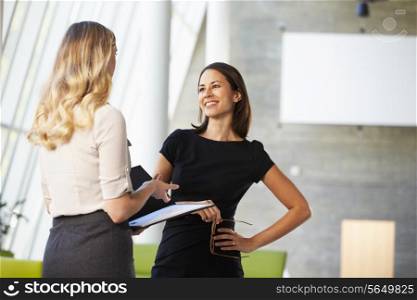 Two Businesswomen Having Informal Meeting In Modern Office