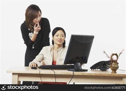 Two businesswomen looking at a computer