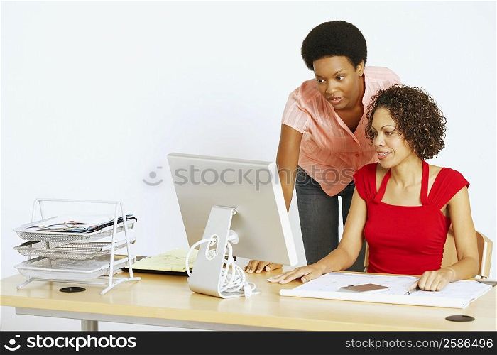 Two businesswomen looking at a computer in an office