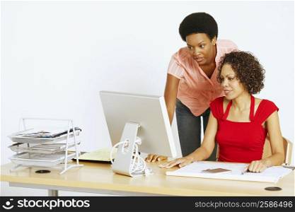 Two businesswomen looking at a computer in an office