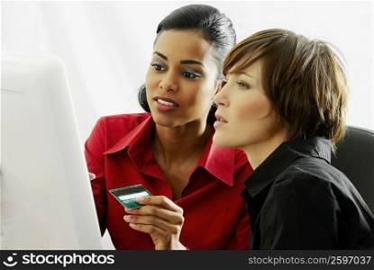 Two businesswomen looking at a computer monitor